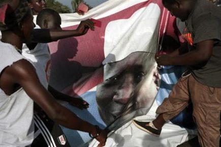 Gambians celebrate the victory of opposition coalition candidate Adama Barrow by tearing down a poster of longtime President Yahya Jammeh in the streets of Serrekunda, Gambia. (AP) 